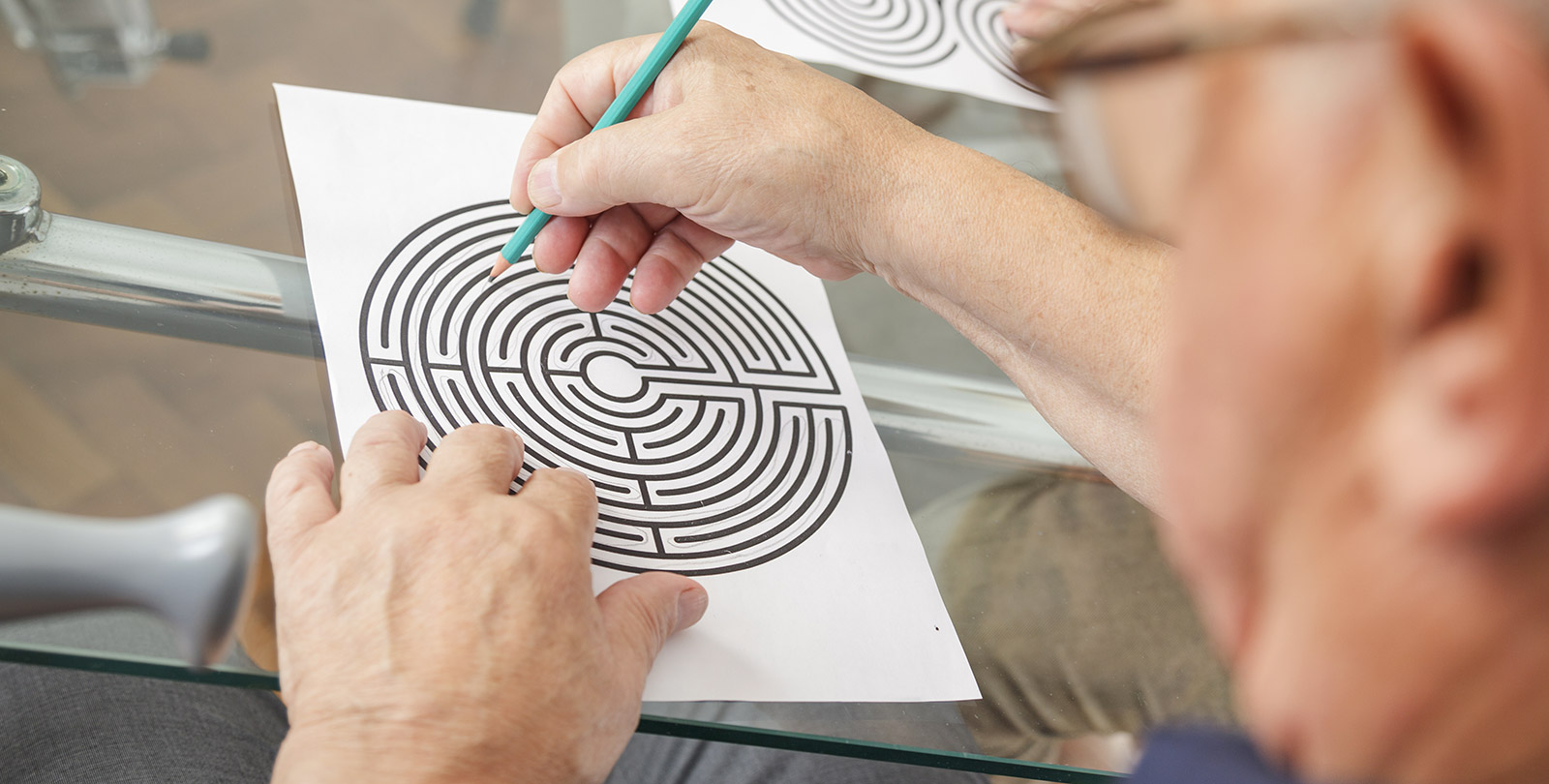 Senior versucht ein Labyrinth-Rtsel mit Stift und Papier zu lsen