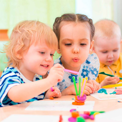 Kinder sitzen am Tisch und basteln
