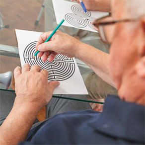 Senior versucht ein Labyrinth-Rtsel mit Stift und Papier zu lsen